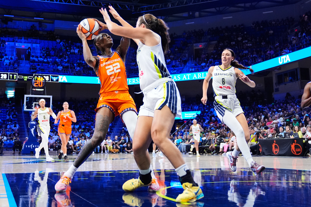 Connecticut Sun guard Saniya Rivers (22) works to take a shot as Dallas Wings' Maddy Siegrist, right, defends during the first half of a WNBA basketball game in Arlington, Texas, Sunday, Aug. 2, 2026. (AP Photo/Tony Gutierrez)