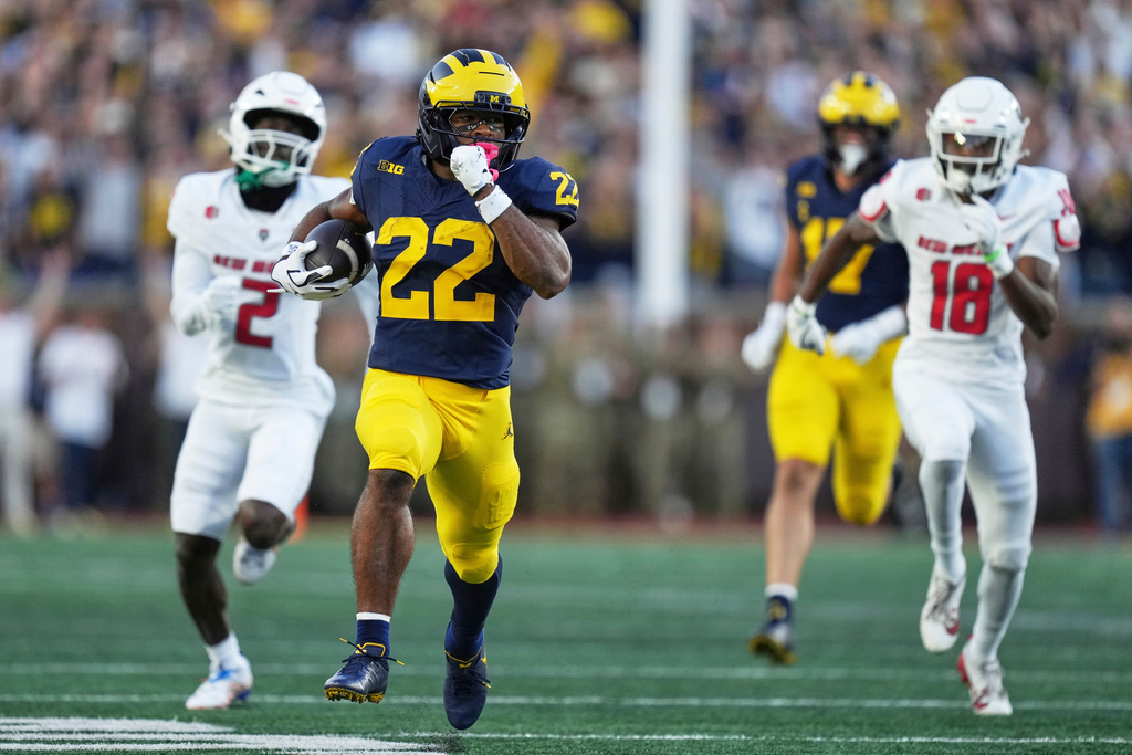 FILE - Michigan running back Justice Haynes (22) runs past New Mexico cornerback Abraham Williams (2) and safety Caleb Coleman (18) to score a touchdown during the first half of an NCAA college football game, Aug. 30, 2025, in Ann Arbor, Mich. (AP Photo/Ryan Sun)