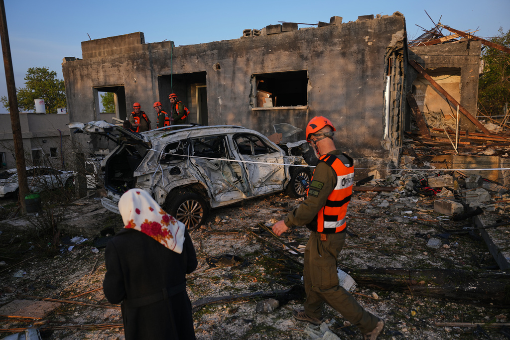 Residents and officers from Israel's Home Front Command inspect a house destroyed by an Iranian missile strike in Zarzir, northern Israel, Friday, March 13, 2026. (AP Photo/Ariel Schalit)