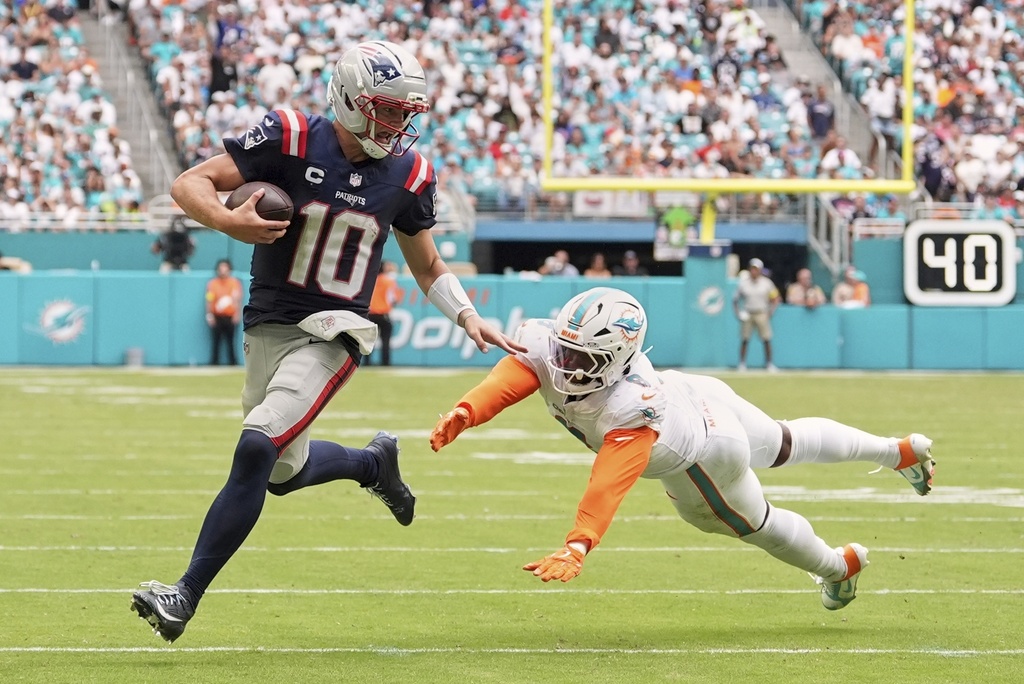New England Patriots' Drake Maye gets past Miami Dolphins' Matthew Judon for a touchdown run during the second half of an NFL football game Sunday, Sept. 14, 2025, in Miami Gardens, Fla. (AP Photo/Rebecca Blackwell)