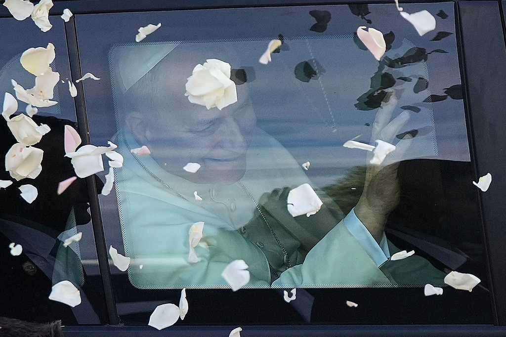 FILE - Rose petals are tossed towards Pope Leo XIV as he is driven past after visiting the Psychiatric Hospital of the Cross in Jal el-Dib, Lebanon, Dec. 2, 2025. (AP Photo/Hassan Ammar, File)