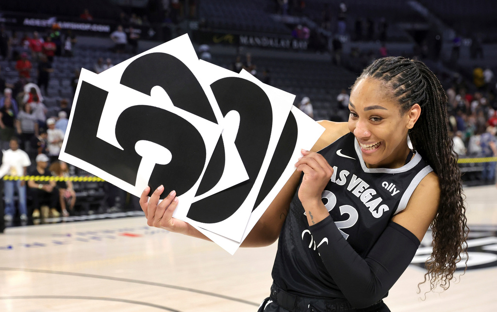 FILE - Las Vegas Aces center A'ja Wilson (22) holds up numbers to commemorate her WNBA career 5,000 points after the Aces defeated the Connecticut Sun in a WNBA basketball game Wednesday, June 25, 2025, in Las Vegas. (Steve Marcus/Las Vegas Sun via AP, File)