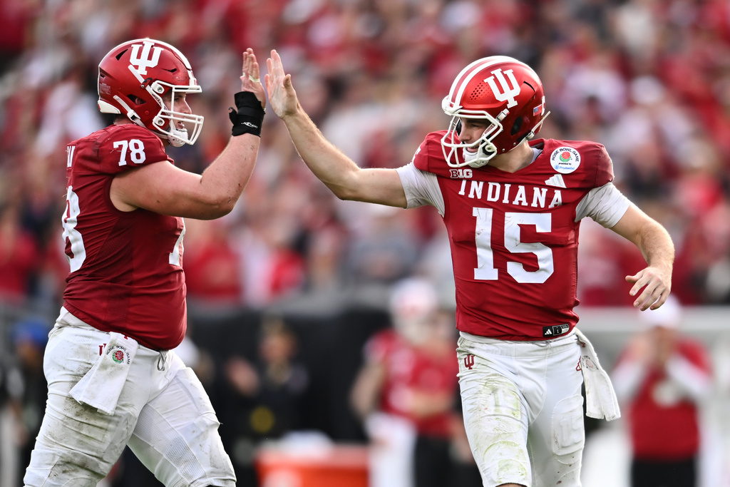 Indiana quarterback Fernando Mendoza (15) celebrates with offensive lineman Jackson Lloyd (78) after throwing a touchdown pass to wide receiver Elijah Sarratt during the second half of the Rose Bowl College Football Playoff quarterfinal game Thursday, Jan. 1, 2026, in Pasadena, Calif. (AP Photo/Kyusung Gong)