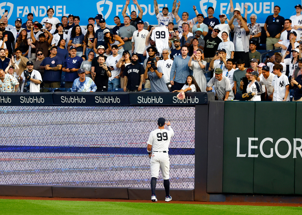 New York Yankees' right fielder Aaron Judge (99) tosses a ball to a fan during the first inning of a baseball game, Tuesday, Sept. 8, 2026, in New York. (AP Photo/Noah K. Murray)