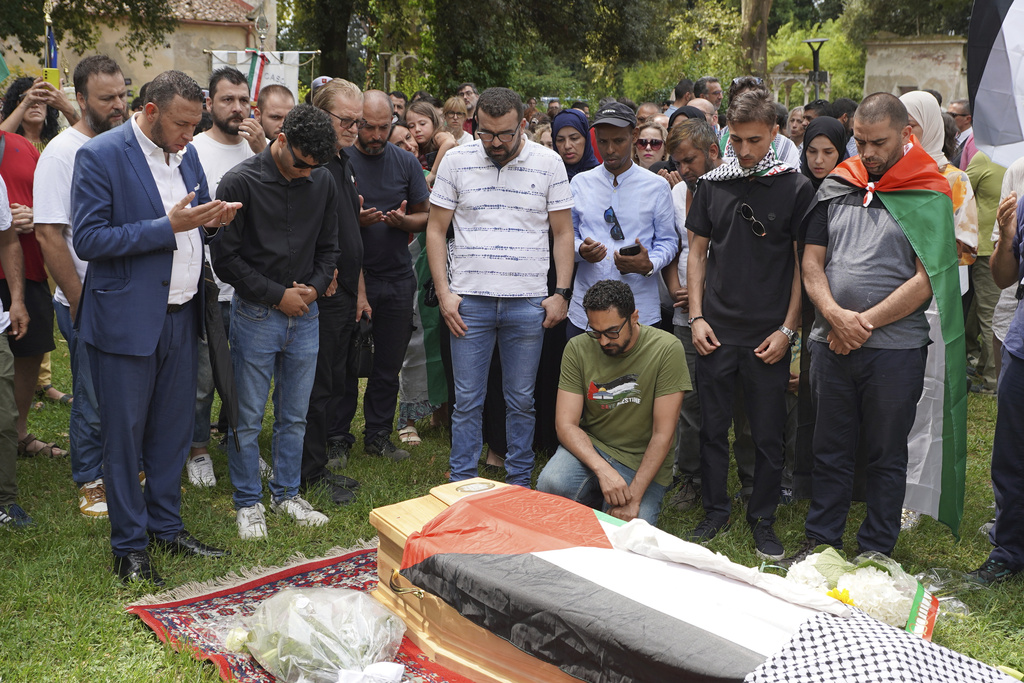 Mourners gather around the coffin of 19-year-old Palestinian woman Marah Abu Zhuri during her funeral in Pontesserchio, near Pisa, Italy, Wednesday Aug. 20, 2025, who died there after being evacuated from Gaza. (Alessandro La Rocca/LaPresse via AP)