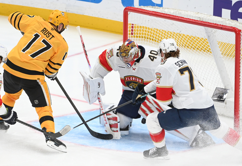Pittsburgh Penguins right wing Bryan Rust (17) scores a goal between the legs of Florida Panthers goalie Daniil Tarasov (40) as center Cole Schwindt (79) defends during the third period of an NHL hockey game, Sunday, April 5, 2026, in Pittsburgh. (AP Photo/Philip G. Pavely)
