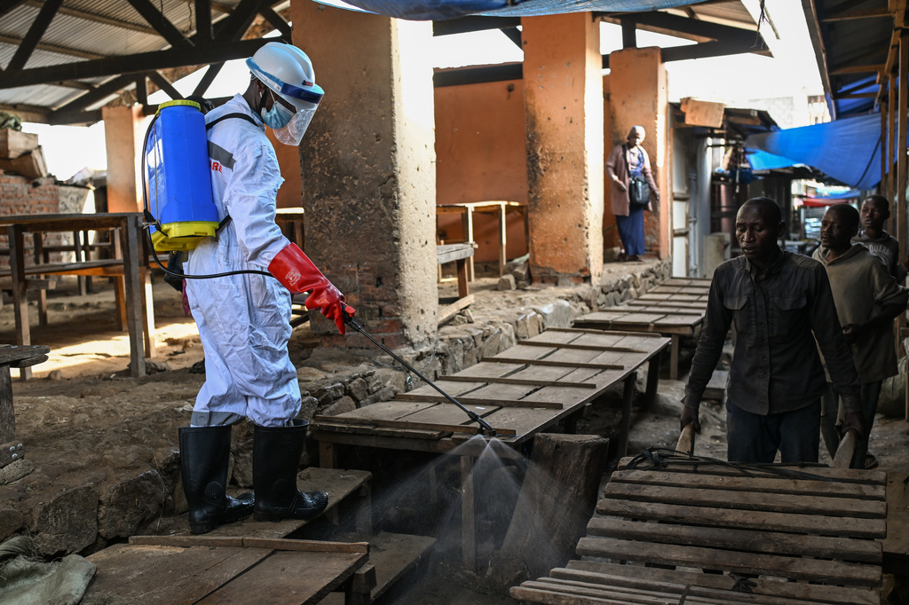 A sanitation worker from the Bunia city government sprays chlorine to disinfect the central market, as Ituri province continues to combat an Ebola outbreak, in Bunia, Congo, Saturday, May 23, 2026. (AP Photo/Moses Sawasawa)