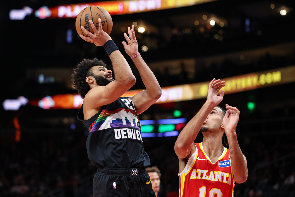 Denver Nuggets guard Jamal Murray, left, shoots against Atlanta Hawks forward Zaccharie Risacher during the first half of an NBA basketball game, Friday, Dec. 5, 2025, in Atlanta. (AP Photo/Colin Hubbard)