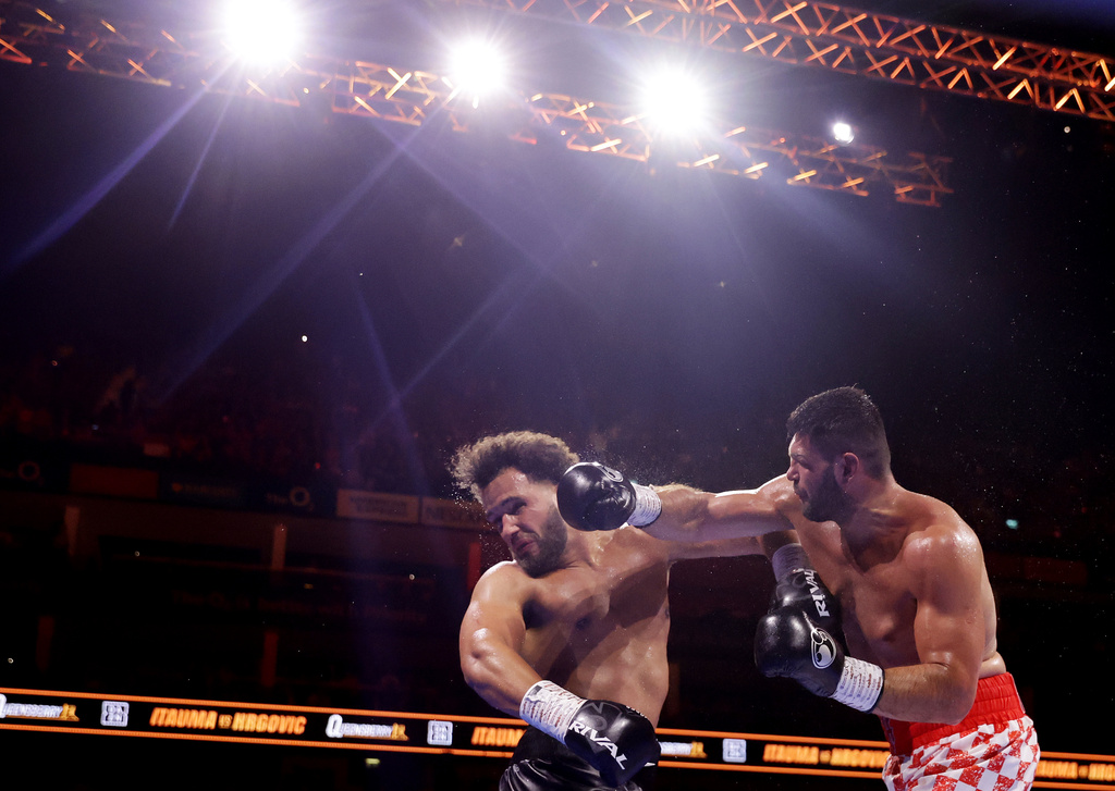 Boxer Filip Hrgovic , right, punches Moses Itauma during their vacant IBF world heavyweight title, Saturday, Aug. 29, 2026, in London. (Steven Paston/PA via AP)