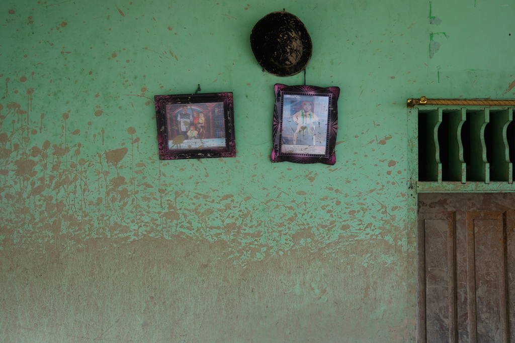 Water level mark is visible on a wall of a house where family photos hang at a village affected by a flash flood in Batang Toru, North Sumatra, Indonesia, Tuesday, Dec. 2, 2025. (AP Photo/Binsar Bakkara)