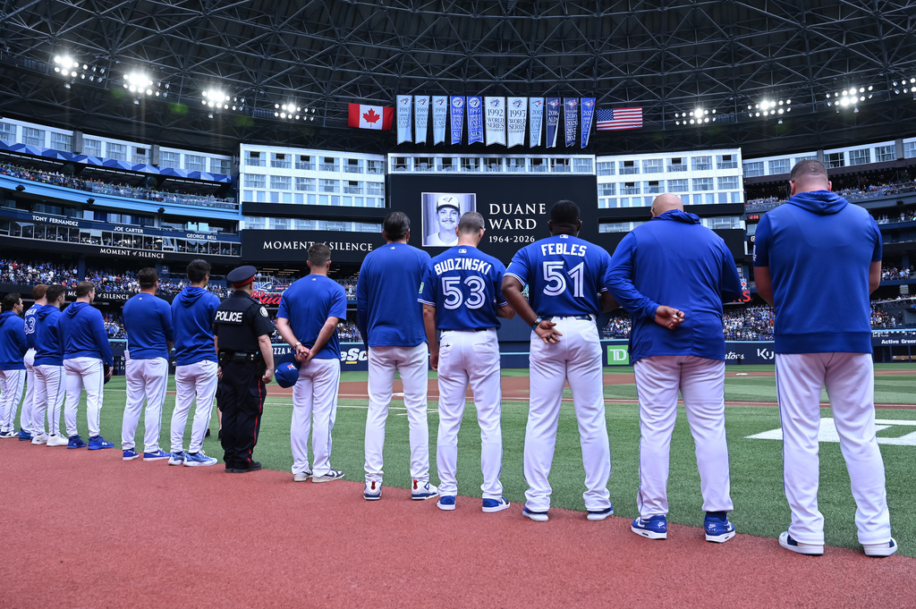 Players and coaches of the Toronto Blue Jays recognize a moment of silence on the announcement of the passing of former Blue Jays pitcher Duane Ward prior to the start of the game against the Chicago White Sox in MLB baseball action in Toronto on Sunday, July 19, 2026. (Jon Blacker/The Canadian Press via AP)