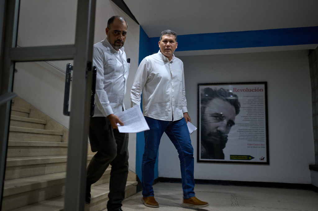 Director of the International Press Center, (CPI), Abel Ernesto Derivet Vidal, left, and Cuba's Deputy Prime Minister Oscar Perez-Oliva Fraga walk past an image of the late Fidel Castro as they arrive for a press conference at the CPI in Havana, Cuba, Thursday, Sept. 3, 2026. (AP Photo/Ramon Espinosa)