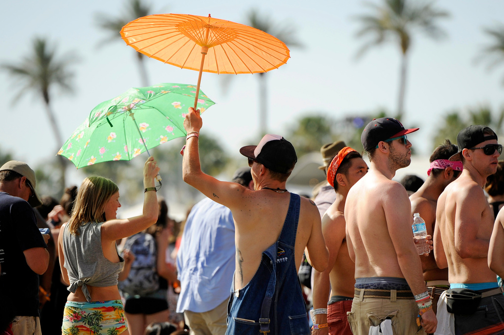 FILE - Festivalgoers shield themselves from the sun at the Coachella Music and Arts Festival in Indio, Calif., on April 13, 2014. (Photo by Chris Pizzello/Invision/AP, File)