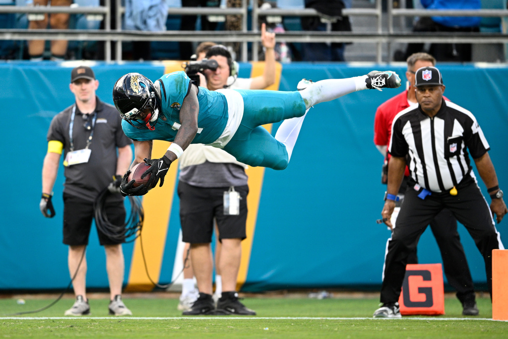 Jacksonville Jaguars running back Travis Etienne Jr. (1) scores a touchdown against the New York Jets during the second half of an NFL football game, Sunday, Dec. 14, 2025, in Jacksonville, Fla. (AP Photo/Phelan M. Ebenhack)