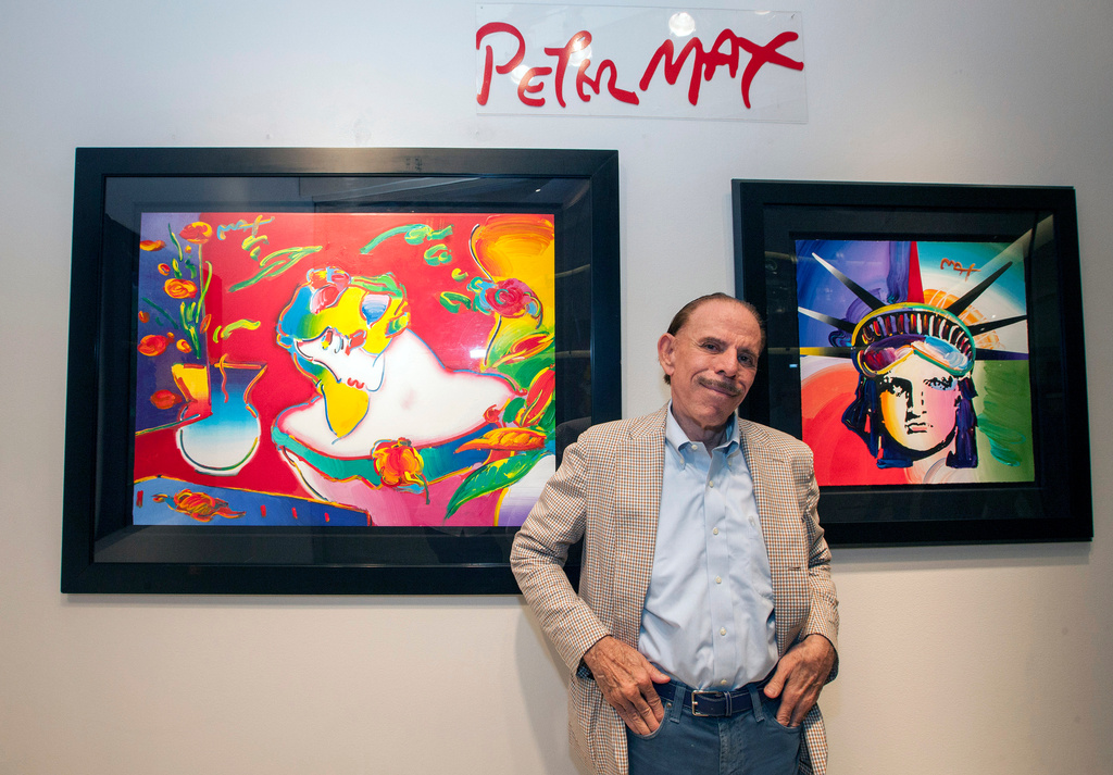 FILE - Artist Peter Max poses for a photo during his retrospective with the Road Show Company exhibit, Sept. 6, 2014, in Northbrook Court mall in Northbrook, Ill. (Photo by Barry Brecheisen/Invision/AP, File)