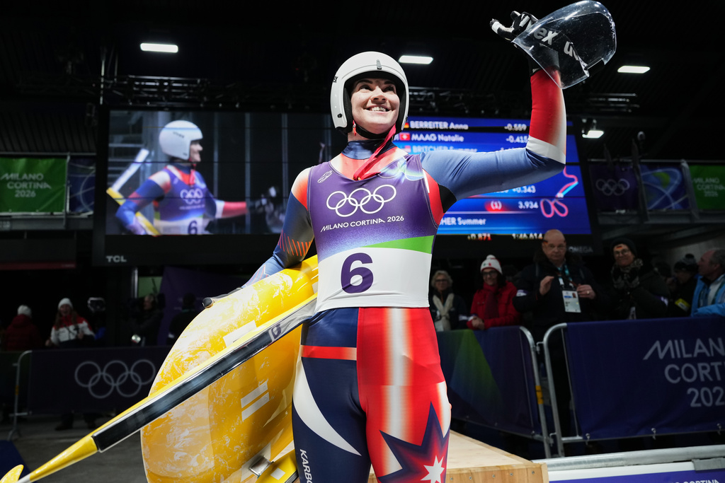 United States' Summer Britcher waves as she arrives at the finish during a women's single luge run at the 2026 Winter Olympics, in Cortina d'Ampezzo, Italy, Monday, Feb. 9, 2026. (AP Photo/Alessandra Tarantino)