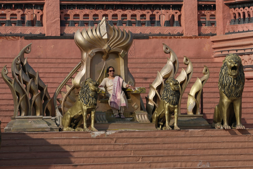 A visitor sits on a throne on the sets of Bahubali in Ramoji Film City, in Hyderabad, India, Tuesday, Nov. 18, 2025. (AP Photo/Mahesh Kumar A.)