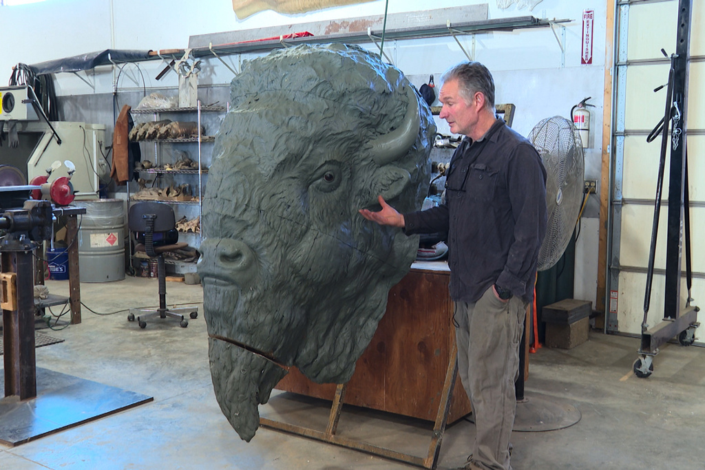 Paleoartist Gary Staab stands next to one of the clay sculptures of bison statues he crafted at his studio in Kearney, Mo., on Tuesday, Dec. 2, 2025. (AP Photo/Nick Ingram)