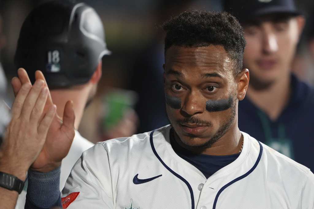 Seattle Mariners' Jorge Polanco is greeted in the dugout after scoring on a two-run single from J.P. Crawford against the San Diego Padres during the fifth inning of a baseball game Monday, Aug. 25, 2025, in Seattle. (AP Photo/Lindsey Wasson)