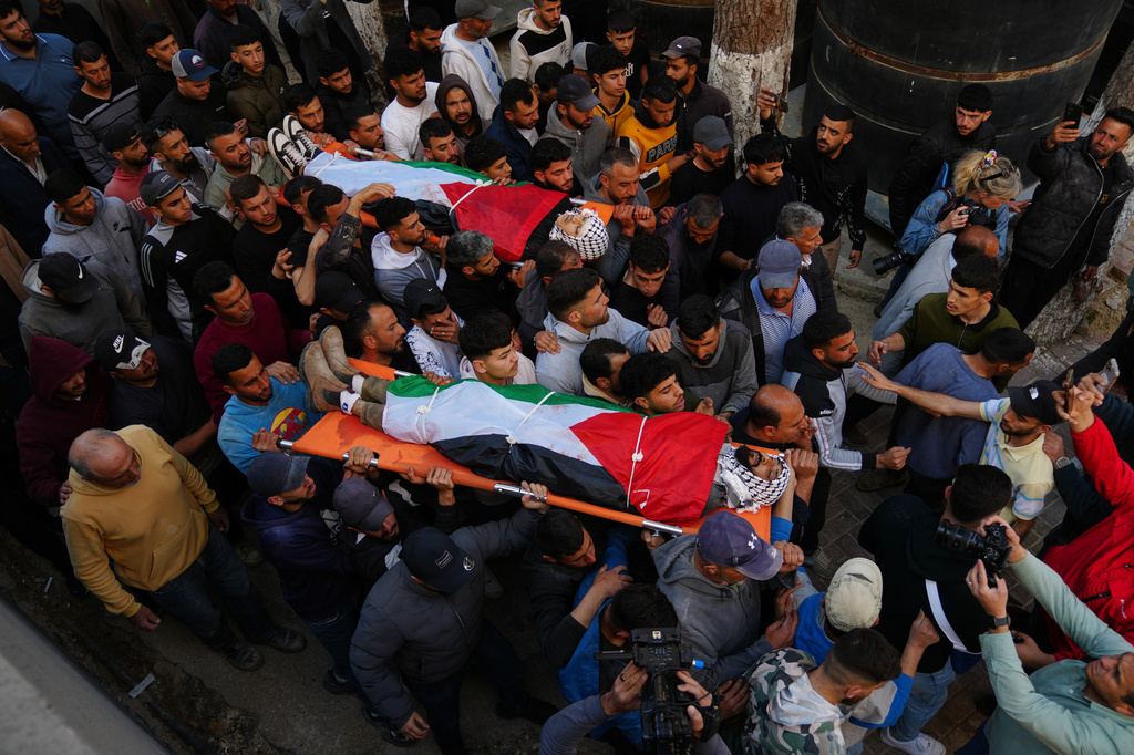 Mourners carry the bodies of Aws al-Na'san and Jihad Abu Naim, residents of the West Bank village of al-Mughayyir, out of the hospital's morgue in the West Bank city of Ramallah, Tuesday, April 21, 2026. (AP Photo/Mahmoud Illean)
