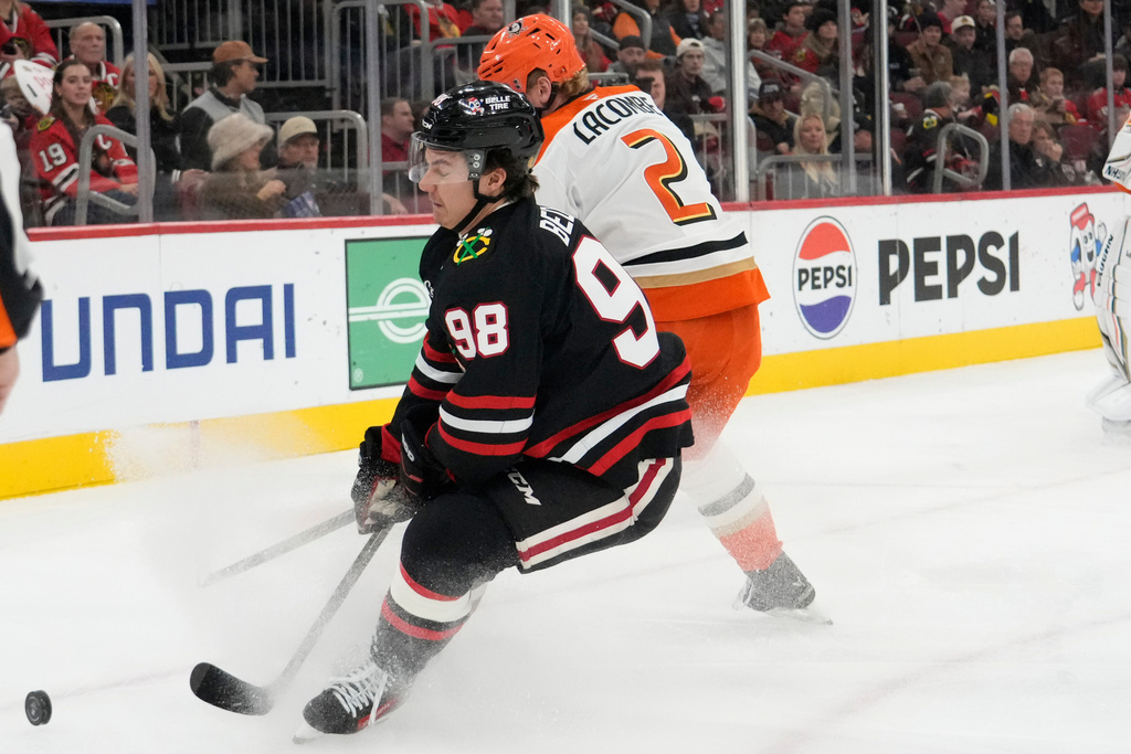 Anaheim Ducks defenseman Jackson Lacombe (2) works against Chicago Blackhawks center Connor Bedard (98) during the first period of an NHL hockey game Sunday, Nov. 30, 2025, in Chicago. (AP Photo/David Banks)