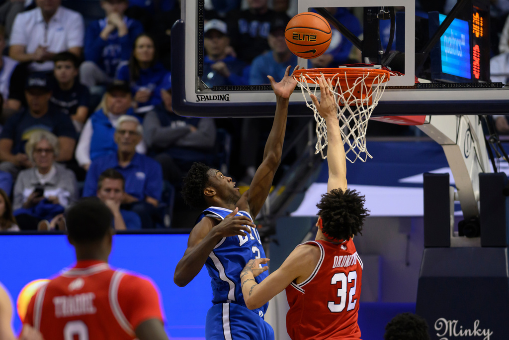 BYU forward AJ Dybantsa, center, shoots a layup over Utah forward James Okonkwo, right, during the second half of an NCAA college basketball game, Saturday, Jan. 24, 2026, in Provo, Utah. (AP Photo/Tyler Tate)