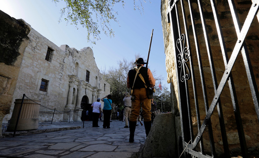 FILE - In this Feb. 24, 2016, file photo, a member of the San Antonio Living History Association stands on the grounds on the Alamo as he waits to take part in a reenactment to deliver William B. Travis' "Victory or Death" letter, in San Antonio. (AP Photo/Eric Gay, File) FILE - In this Feb. 24, 2016, file photo, a member of the San Antonio Living History Association stands on the grounds on the Alamo as he waits to take part in a reenactment to deliver William B. Travis' "Victory or Death" letter, in San Antonio. (AP Photo/Eric Gay, File)