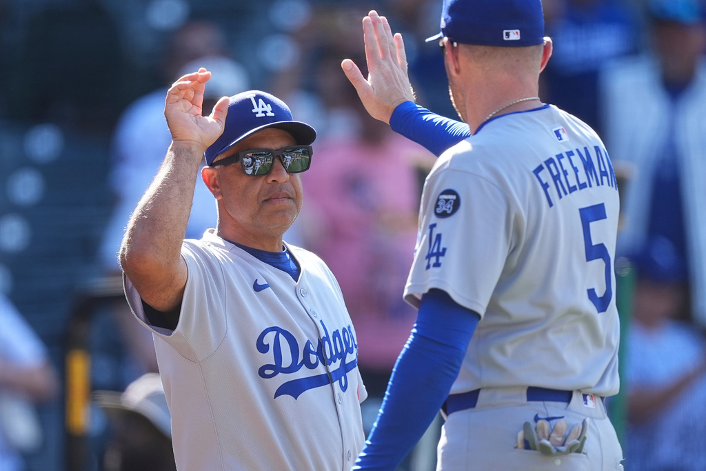 FILE - Los Angeles Dodgers manager Dave Roberts (30) congratulates first baseman Freddie Freeman (5) after defeating the Colorado Rockies in a baseball game Aug. 21, 2025, in Denver. (AP Photo/David Zalubowski, File)