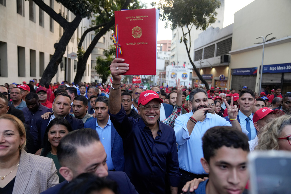National Assembly President Jorge Rodriguez takes part in a rally holding up a copy of a new law after lawmakers approved legislation opening the nation's oil sector to privatization, in Caracas, Venezuela, Thursday, Jan. 29, 2026. (AP Photo/Ariana Cubillos)