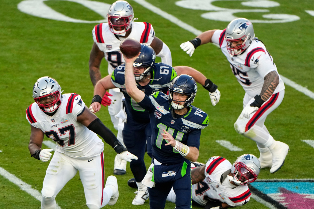 Seattle Seahawks quarterback Sam Darnold (14) throws a pass under pressure from New England Patriots defensive end Milton Williams (97) during the first half of the NFL Super Bowl 60 football game, Sunday, Feb. 8, 2026, in Santa Clara, Calif. (AP Photo/Charlie Riedel)