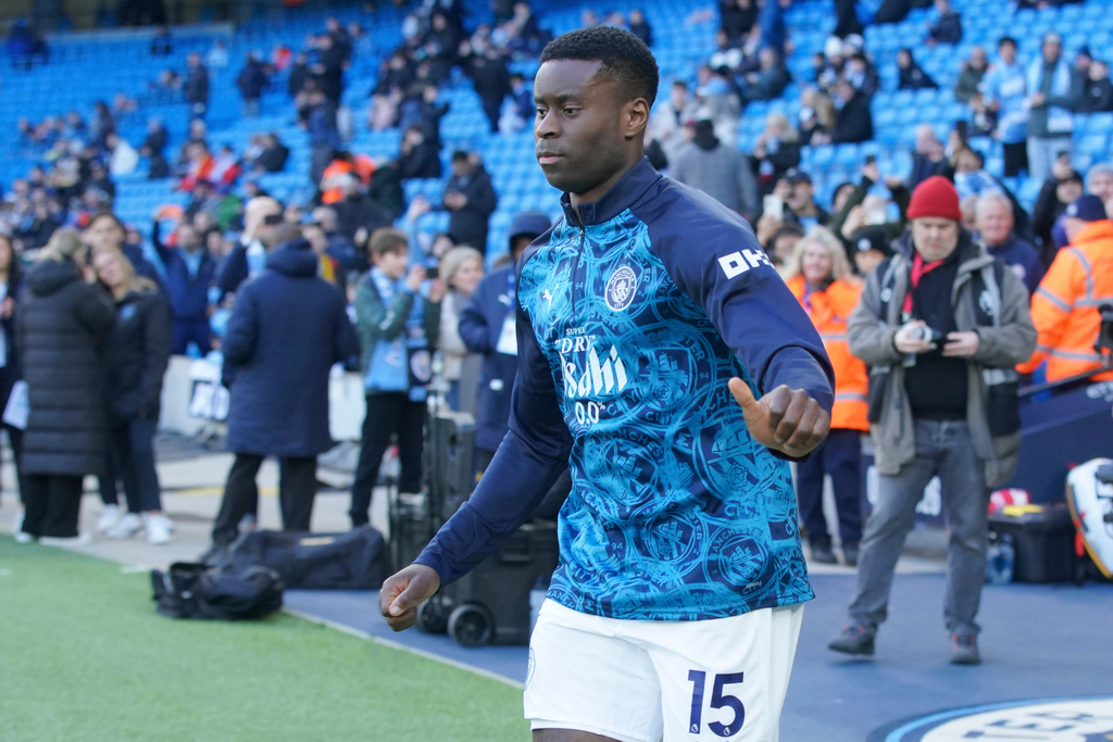 Manchester City's Marc Guehi runs out onto the pitch ahead of making his debut for City, as he takes part in the warm up before the start of of the English Premier League soccer match between Manchester City and Wolverhampton Wanderers in Manchester, England, Saturday, Jan. 24, 2026. (AP Photo/Ian Hodgson)