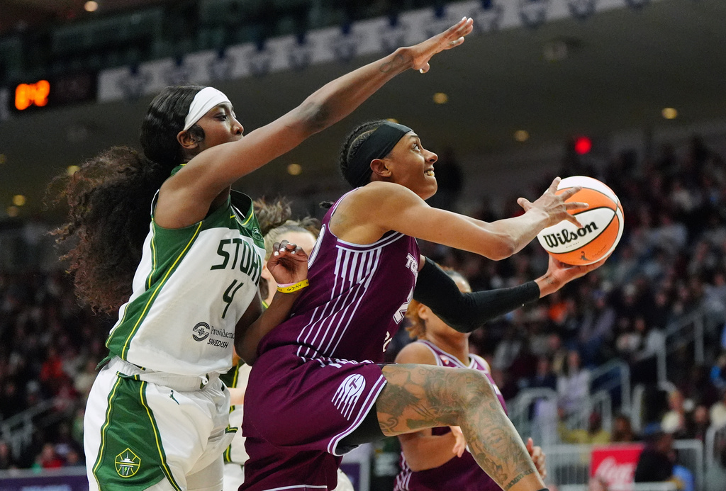 Seattle Storm's Flau'jae Johnson (4) tries to defend against Toronto Tempo's Brittney Sykes (20) as she drives to the hoop during the second half of a WNBA basketball game in Toronto, on Wednesday, May 13, 2026. (Frank Gunn/The Canadian Press via AP)