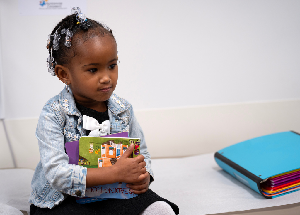 Juri Sleet, 4, holds a pair of books after completing a literacy screening at Linden Primary Care Center at Nationwide Children's Hospital, Thursday, Dec. 11, 2025, in Columbus, Ohio. (AP Photo/Jessica Phelps)