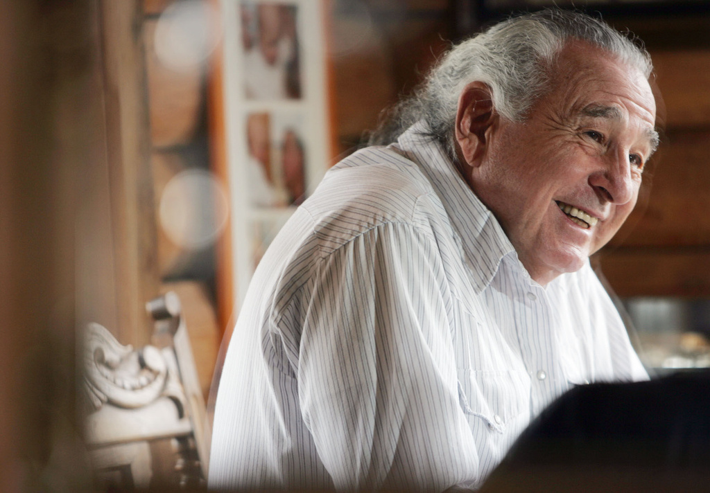 FILE - Retired U.S. Sen. Ben Nighthorse Campbell jokes with a reporter as his image is seen reflected in a mirror positioned in a hutch in his home in Ignacio, Colo., Jan. 11, 2005. (AP Photo/David Zalubowski, File)