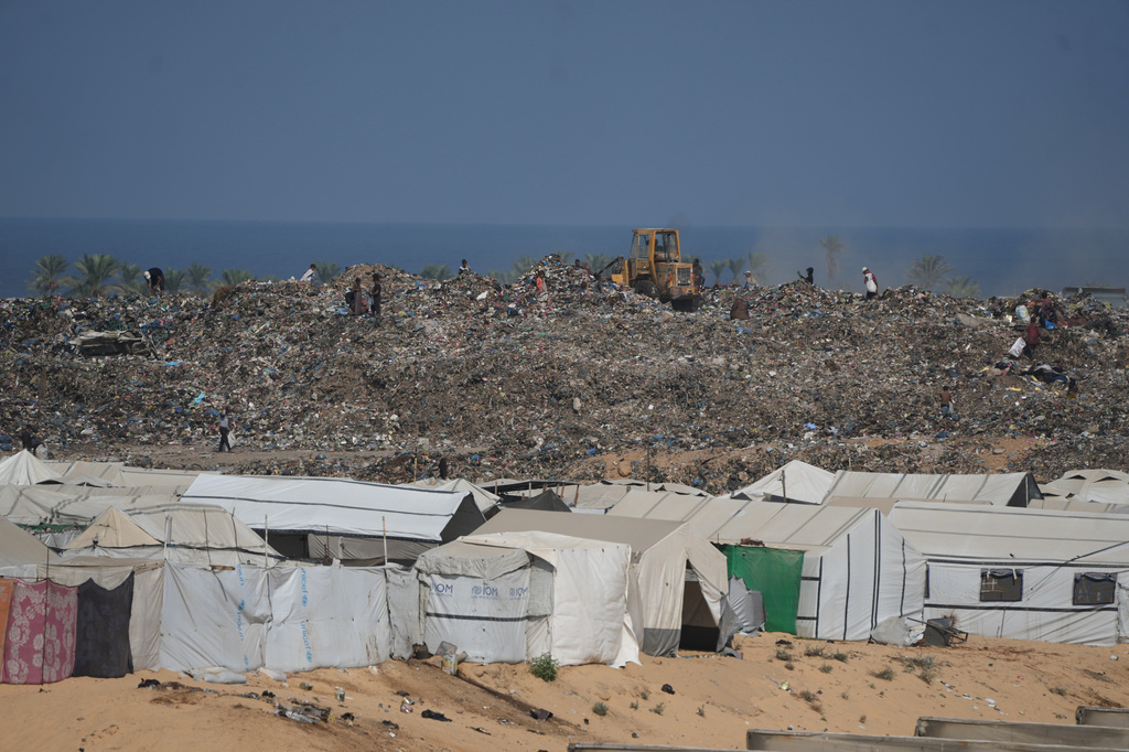 Palestinians search through a garbage dump for combustible materials to use as fuel for cooking due to a shortage of cooking gas, in Deir al-Balah, central Gaza Strip, Saturday, Aug. 22, 2026. (AP Photo/Abdel Kareem Hana)