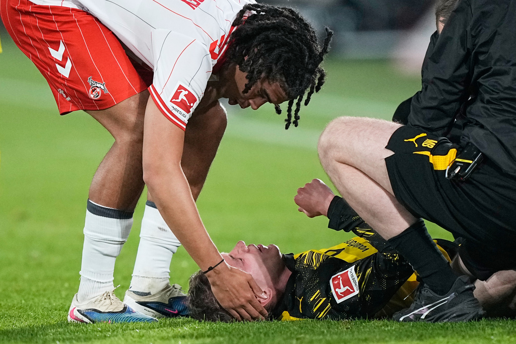 Cologne's Jahmai Simpson-Pusey, left, comforts fouled Dortmund's Maximilian Beier, before he gets the red card during a German Bundesliga soccer match between 1.FC Koeln and Borussia Dortmund in Cologne, Germany, Saturday, March 7, 2026. (AP Photo/Martin Meissner)