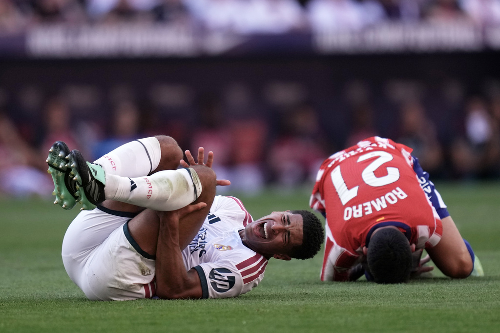 Real Madrid's Jude Bellingham and Atletico Madrid's Cristian Romero grimace on the ground after a collision during a Spanish La Liga soccer match between Atletico Madrid and Real Madrid in Madrid, Sunday, Sept. 20, 2026. (AP Photo/Bernat Armangue)