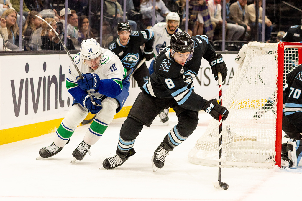 Utah Mammoth center Nick Schmaltz (8) moves the puck against Vancouver Canucks left wing Drew O'Connor (18) during the second period of an NHL hockey game Monday, Feb. 2, 2026, in Salt Lake City. (AP Photo/Melissa Majchrzak)