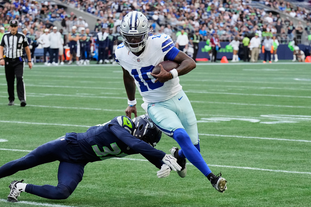 Dallas Cowboys quarterback Joe Milton III (10) runs the ball as Seattle Seahawks cornerback Michael Dansby (37) attempts to make the stop in the second half of an NFL preseason football game, Saturday, Aug. 15, 2026, in Seattle. (AP Photo/Stephen Brashear)