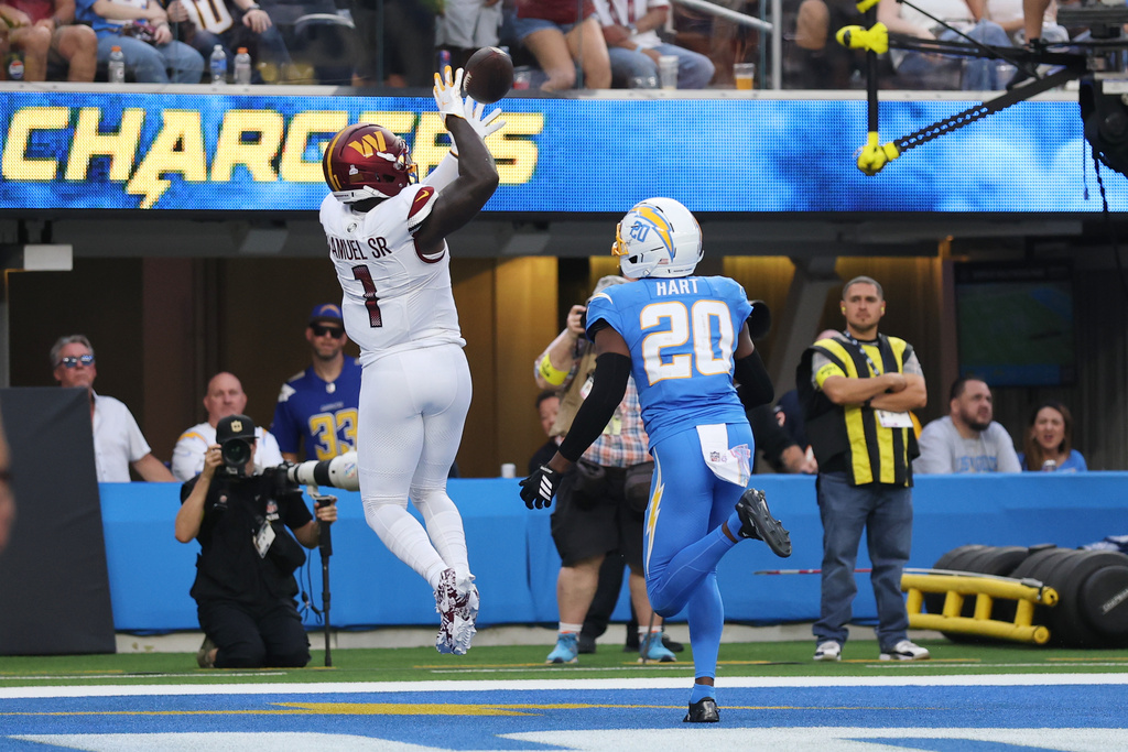 Washington Commanders wide receiver Deebo Samuel Sr. (1) catches a touchdown past Los Angeles Chargers cornerback Cam Hart (20) during the second half of an NFL football game Sunday, Oct. 5, 2025, in Inglewood, Calif. (AP Photo/Eric Thayer)