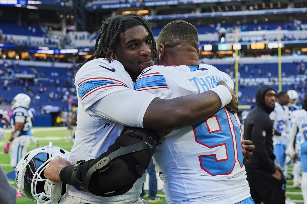 Tennessee Titans quarterback Cam Ward, left, celebrates the team's wins with defensive tackle Solomon Thomas (90) after an NFL football game against the Indianapolis Colts, Sunday, Oct. 18, 2026, in Indianapolis. (AP Photo/Jeff Roberson)