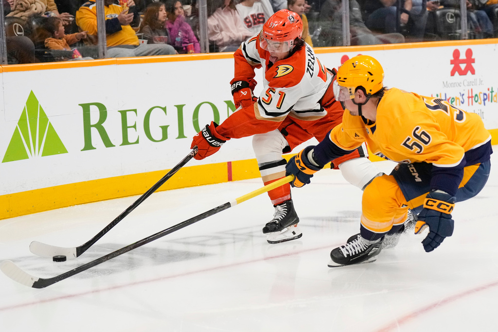 Anaheim Ducks defenseman Olen Zellweger (51) and Nashville Predators left wing Erik Haula (56) chase the puck during the second period of an NHL hockey game Tuesday, Oct. 21, 2025, in Nashville, Tenn. (AP Photo/George Walker IV)