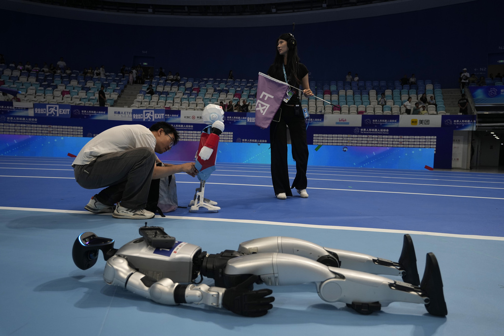 A worker prepares a robot before the opening ceremony of The World Humanoid Robot Games held in Beijing, China, Thursday, Aug. 14, 2025. (AP Photo/Ng Han Guan)