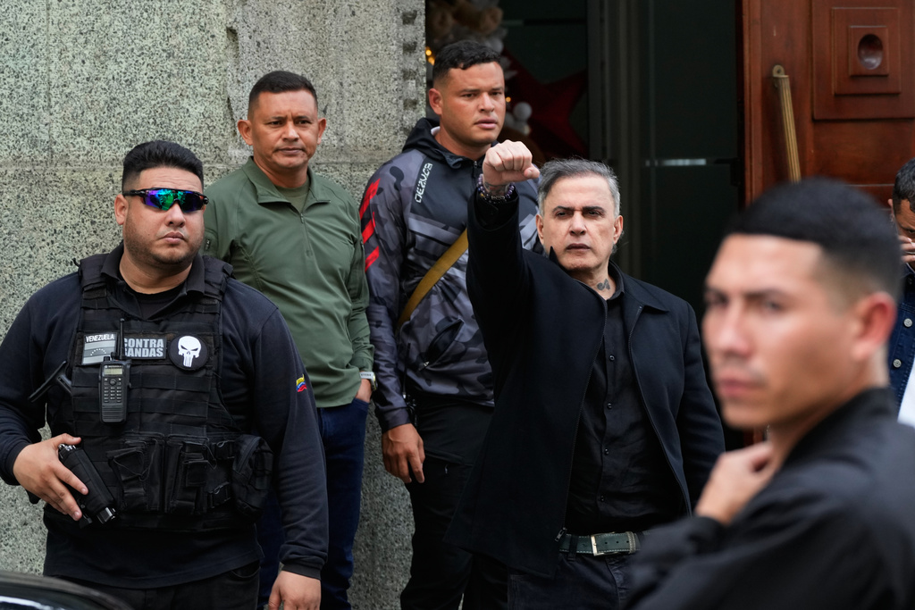 Attorney General Tarek William Saab raises his right fist as he leaves the vice president's office in Caracas, Venezuela, Saturday, Jan. 3, 2026. (AP Photo/Ariana Cubillos)