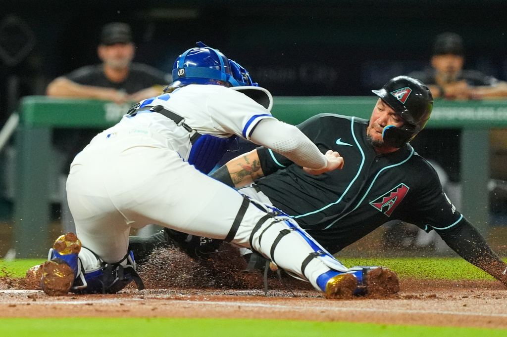 Arizona Diamondbacks' Ildemaro Vargas is tagged out by Kansas City Royals catcher Carter Jensen while trying to score on a fielder's choice hit by Nolan Arenado during the first inning of a baseball game Wednesday, Sept. 9, 2026, in Kansas City, Mo. (AP Photo/Charlie Riedel)