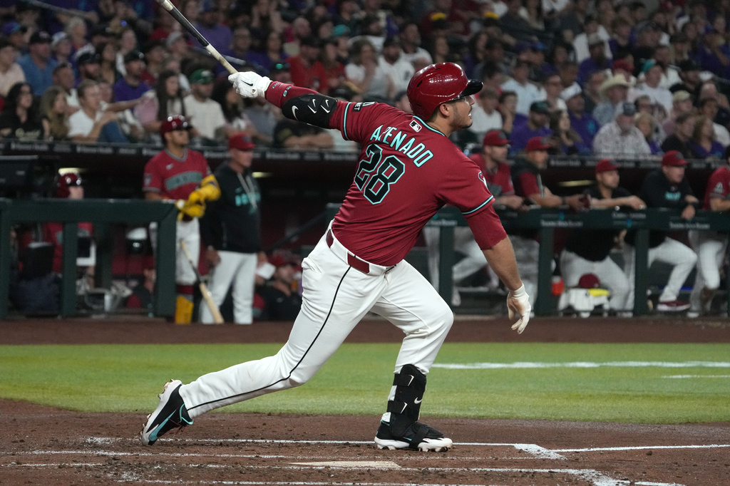 Arizona Diamondbacks' Nolan Arenado hits a two-run double against the Colorado Rockies in the third inning of a baseball game, Saturday, May 23, 2026, in Phoenix. (AP Photo/Rick Scuteri)