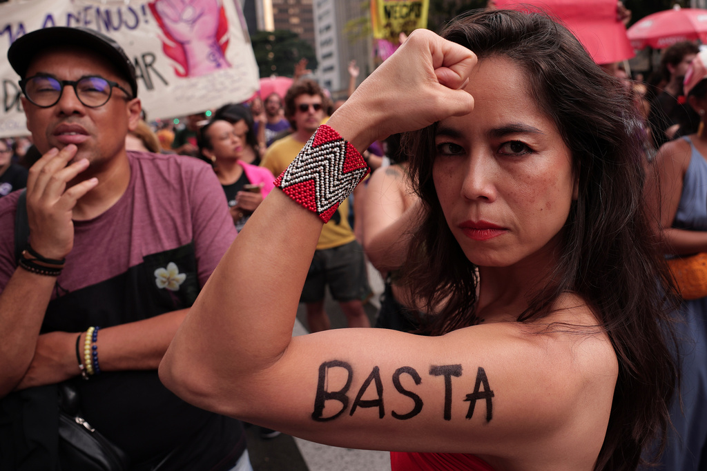 A demonstrator shows the word "Enough" written on her arm in Portuguese, during a march against femicide following a series of high-profile cases in the country, in Sao Paulo, Sunday, Dec. 7, 2025. (AP Photo/Ettore Chiereguini)