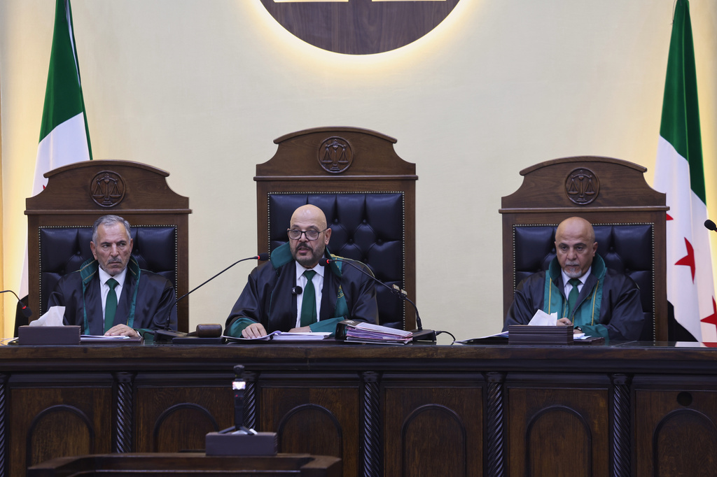 Judge Fakhreddine al-Aryan, center, head of the Fourth Criminal Court, reads the ruling sentencing Syria's former grand mufti under ousted President Bashar Assad, Ahmad Badreddine Hassoun, to life in prison at the Palace of Justice in Damascus, Syria, Monday, Aug. 24, 2026. (AP Photo/Ghaith Alsayed)