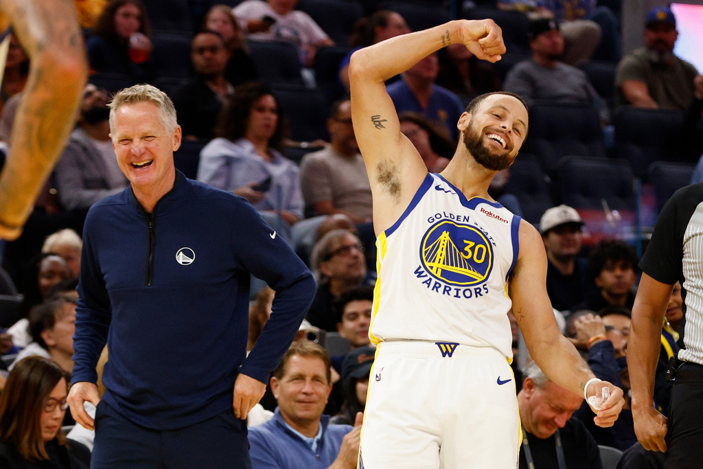 Golden State Warriors head coach Steve Kerr, left, and Warriors guard Stephen Curry (30) laugh in the fourth quarter during an NBA preseason game against the LA Clippers at Chase Center in San Francisco, Friday, Oct. 17, 2025. (Santiago Mejia/San Francisco Chronicle via AP)