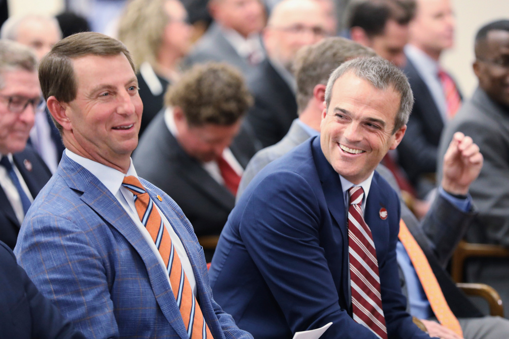 FILE - Clemson football coach Dabo Swinney, left, and South Carolina football coach Shane Beamer, right, laugh before a meeting of a South Carolina House committee considering a bill allowing schools to help athletes with name, image and likeness deals Tuesday, Feb. 6, 2024, in Columbia, S.C. (AP Photo/Jeffrey Collins, File)